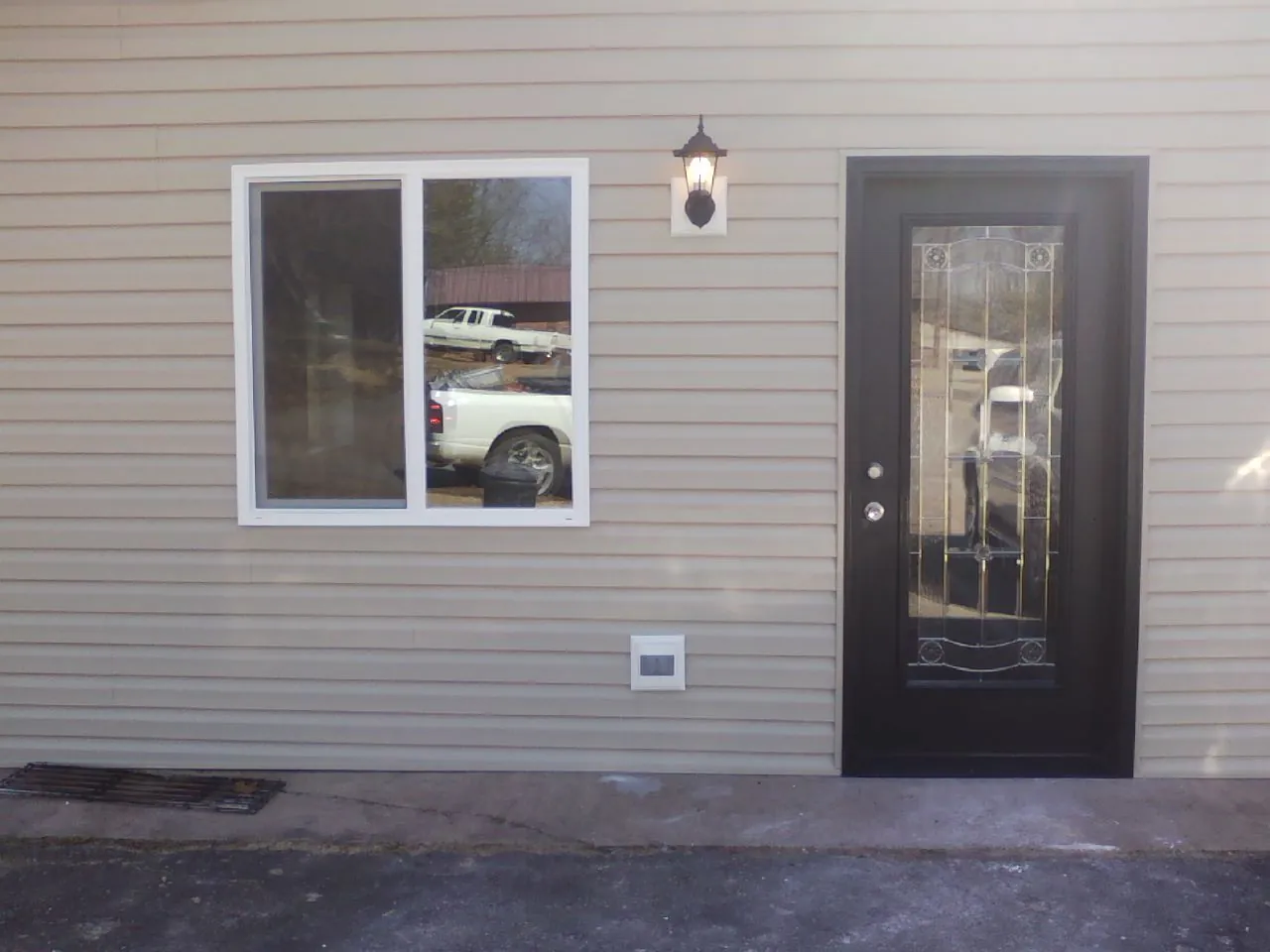 New siding, window and entry door on the side of an addition in Hines