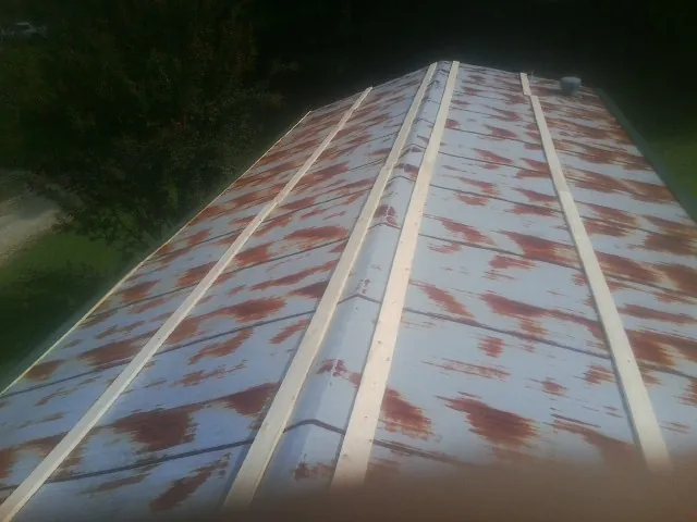 Rusted metal roof panels with new wood purlins before replacement — Storm Damage Roof Repair in Hines by Roofing Brothers