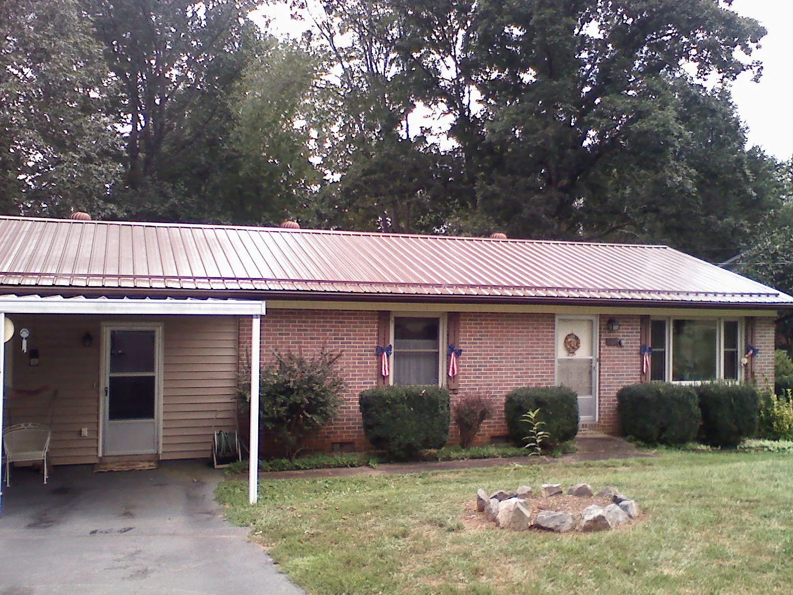 Bronze metal roof and carport on a brick ranch home — Roof Repair work by our crew in Hines
